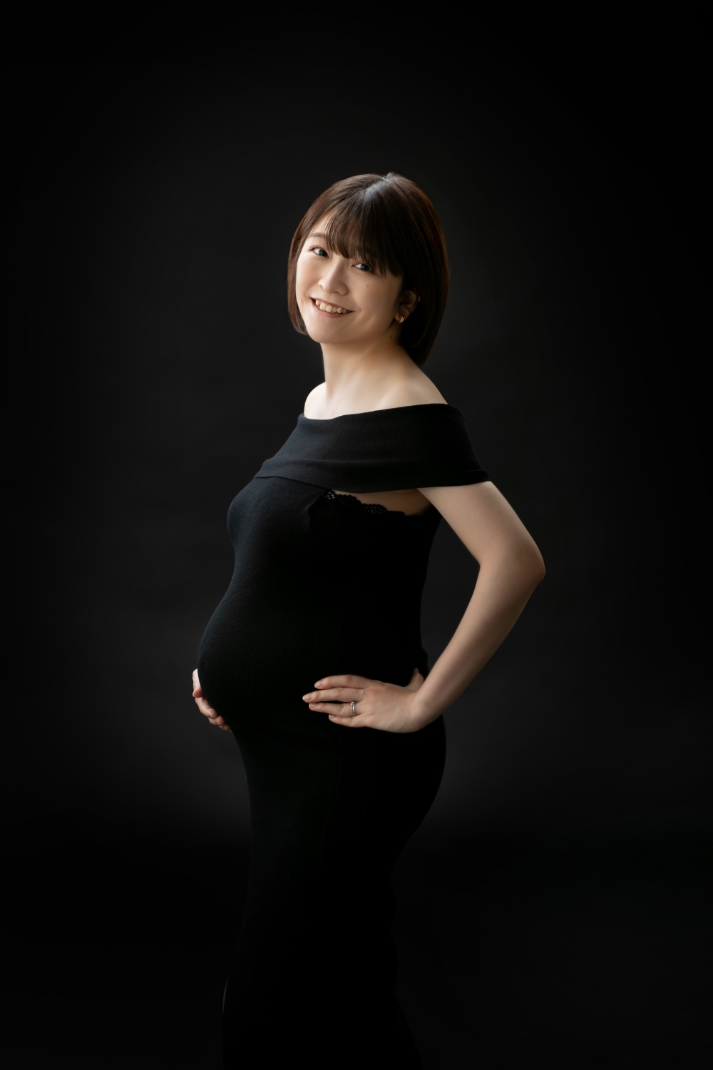 黒いドレスを着て微笑む妊婦さんの写真